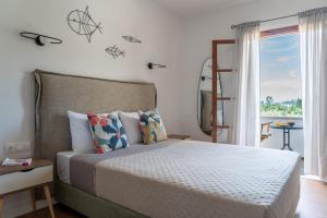 a bedroom with a bed with a view of the ocean at Jimmy's Guest House Skiathos in Skiathos