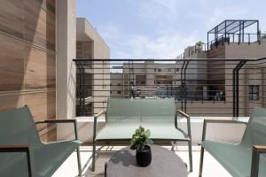 a balcony with two chairs and a table with a plant at דקוטה 11 Dakota in Eilat