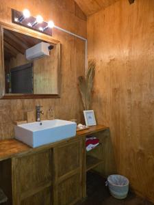 a bathroom with a white sink and a mirror at Jimmys cabins in La Periquera