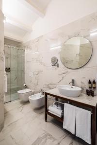 a bathroom with two sinks and a shower and a mirror at Palazzo Artemide - VRetreats, an SLH Hotel in Syracuse