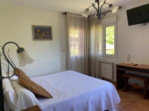 a bedroom with a bed and a desk and a window at Hotel Rural Alavera in San Martin del Mar