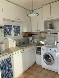 a white kitchen with a washing machine and a sink at Lascar in Royan