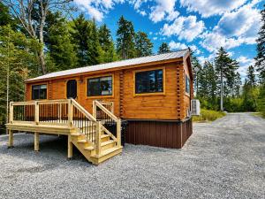 a wooden cabin with a large porch and a staircase at Oceanfront Sunset View Cabin in Milbridge