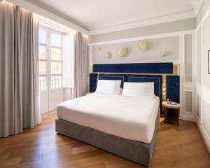 a bedroom with a large bed and a window at Palazzo Artemide - VRetreats, an SLH Hotel in Syracuse