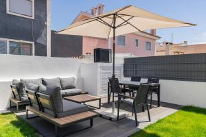 a patio with a table and chairs and an umbrella at Poolside oasis by Caparica beach in Charneca