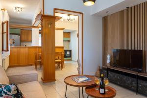 a living room with a couch and a tv and a table at Jimmy's Guest House Skiathos in Skiathos