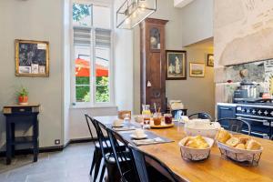 a kitchen with a table with bread in bowls on it at Chambres D'hôtes Les Carmes in La Flocellière +37 photos