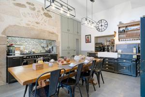 a large kitchen with a wooden table and chairs at Chambres D'hôtes Les Carmes in La Flocellière