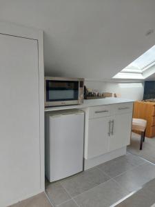 a kitchen with white cabinets and a microwave at Avalon Guest Suite Ewell in Ewell