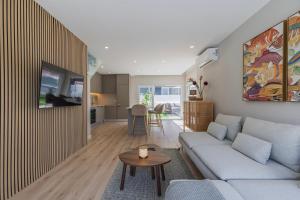 a living room with a couch and a table at Poolside oasis by Caparica beach in Charneca +28 photos