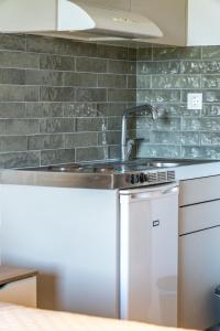 a kitchen with a sink and a counter top at Jimmy's Guest House Skiathos in Skiathos +41 photos