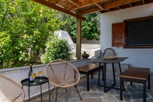 a patio with two tables and chairs and a television at Jimmy's Guest House Skiathos in Skiathos