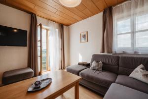 a living room with a couch and a table at Ferienwohnungen Lusenblick in Freyung
