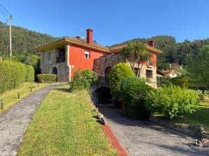 a large orange house with a tunnel in a yard at Hotel Rural Alavera in San Martin del Mar +37 photos