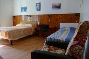 a bedroom with a bed and a chair and a desk at Hôtel Modern in Concarneau