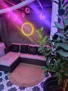 a couch in a room with purple lights at Magic Garden Luxury Pent-house in Bello
