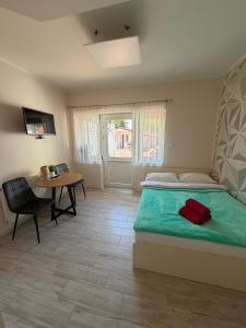 a bedroom with a bed and a table and a window at Pokoje ALbert UL GDAŃSKA 40 in Krynica Morska