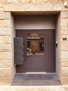a brown door of a store with a sign on it at Escapade au Mont St Michel in Pleine-Fougères