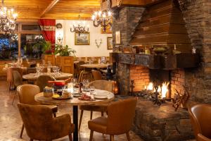 ein Restaurant mit Tischen und einem großen Steinkamin in der Unterkunft Les Cornettes in La Chapelle-dʼAbondance