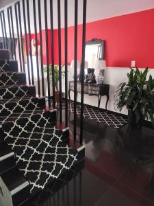 a room with stairs and a red wall and a mirror at Magic Garden Luxury Pent-house in Bello +25 photos