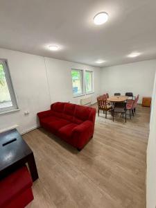 a living room with a red couch and a table at Pokoje przy Żaglach in Rybnik