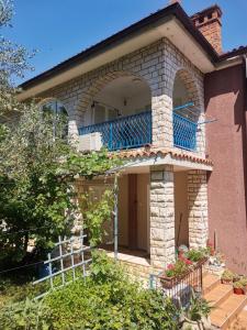 a house with a blue balcony on top of it at IstraCycle in Lucija