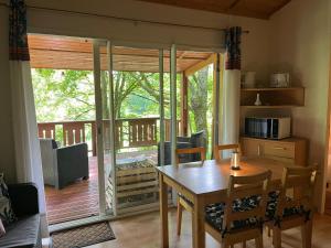 a dining room with a table and a balcony at SAS Le Bataillet in Montégut