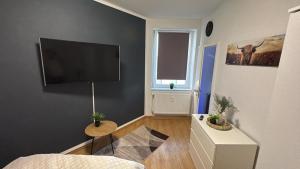 ein Wohnzimmer mit einem Flachbildfernseher an der Wand in der Unterkunft Stadtoase 3 in Wittenberge