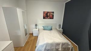 ein Schlafzimmer mit einem Bett, auf dem ein blaues Kissen liegt in der Unterkunft Stadtoase 3 in Wittenberge
