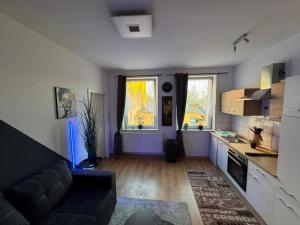 ein Wohnzimmer mit Sofa und eine Küche in der Unterkunft Stadtoase 3 in Wittenberge