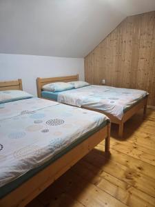 two twin beds in a room with wooden floors at The Wooden House in Moldoveneşti