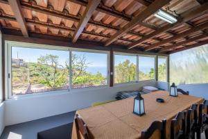 a room with a table and chairs and windows at Casa do Castanheiro in Campanário