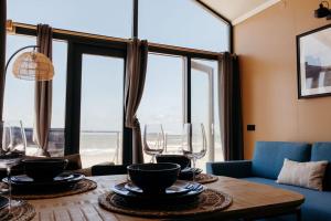 a living room with a table with wine glasses on it at Puur Petten in Petten