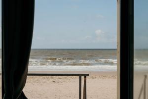 a view of the ocean from a beach with a table at Puur Petten in Petten