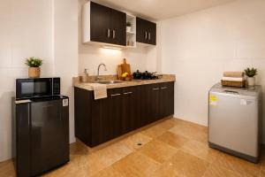 a kitchen with a sink and a microwave and a refrigerator at Apartamento 2 hab en el Centro de la Ciudad wifi in Duitama