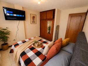 a living room with a couch and a tv at Apartamento 2 hab en el Centro de la Ciudad wifi in Duitama