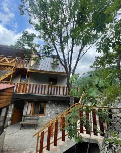 a building with a tree in front of it at Shpia e Mikut Guesthouse in Theth