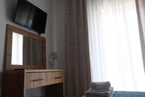 a hotel room with a television and a mirror at Hotel Corali in (( Spile ))