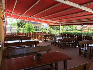 an empty restaurant with wooden tables and benches at Zátonyi Csárda Panzió in Dunasziget
