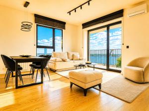 a living room with a table and chairs and windows at Belgrade Waterfront - River Residences in Belgrade