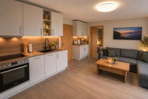 a kitchen and living room with a couch and a table at Ferienhaus Am Achterwasser in Ueckeritz