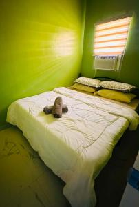 a bed with a stuffed animal on it in a room at Casa Uno Leyte in Palo