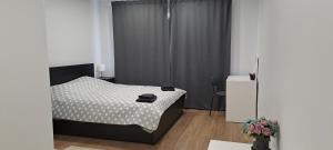a bedroom with a bed with a black and white comforter at Dzīvoklis Baldone, Latvija in Baldone
