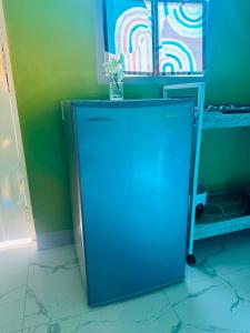 a blue refrigerator in a room with a green wall at Casa Uno Leyte in Palo