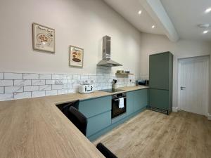 a kitchen with blue cabinets and a counter top at Hazel, Spacious 3-Bed Home in Dowlais +16 photos