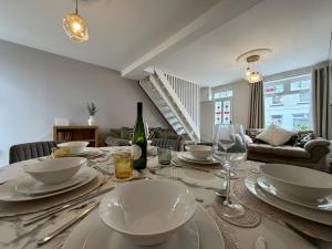 a dining room with a table with plates and wine glasses at Hazel, Spacious 3-Bed Home in Dowlais