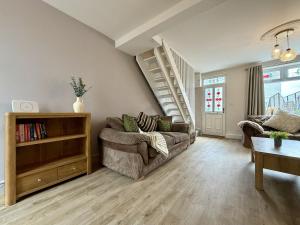 a living room with a couch and a staircase at Hazel, Spacious 3-Bed Home in Dowlais