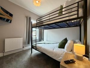 a bedroom with two bunk beds and a desk at Hazel, Spacious 3-Bed Home in Dowlais