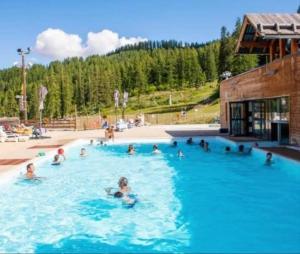 a group of people swimming in a swimming pool at STUDIO 4 personnes in Les Prés