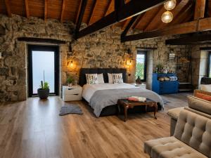 a bedroom with a bed and a stone wall at Open Space com Jacuzzi a 5 mn do centro de Lamego in Lamego
